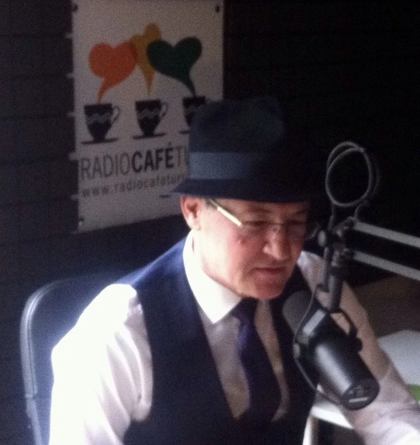 A presenter at the microphone in the Radio Café Turc studio